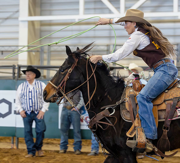 woman on a horse twirling a rope