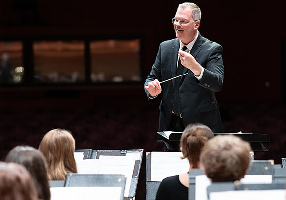 man conducting musicians