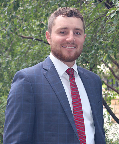 man in a suit posing outside