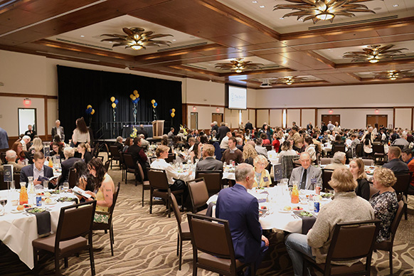 People sit in a large ballroom