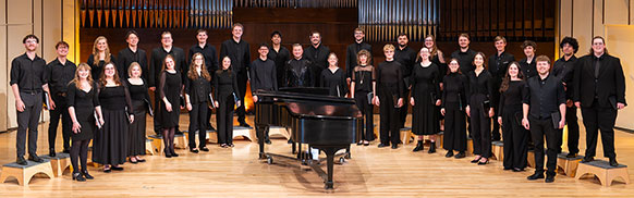choir in black posing on a stage