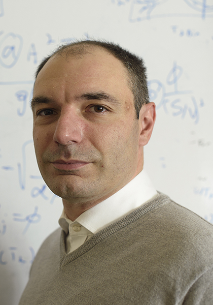 A man stands in front of a white board