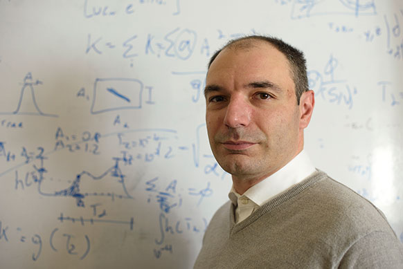 man standing in front of a whiteboard covered with mathmatical equations