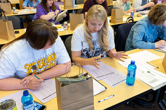 people with papers talking at a table