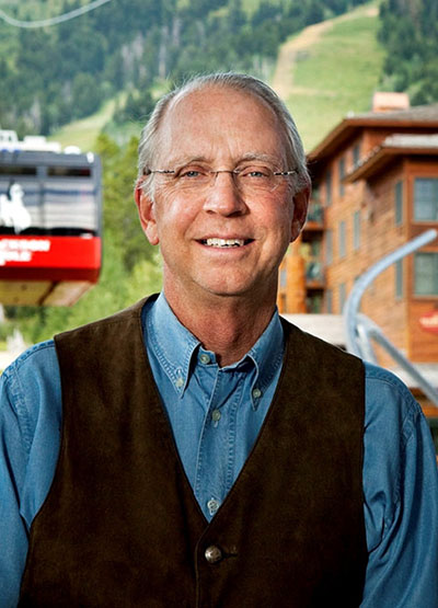 man outside with mountains behind him