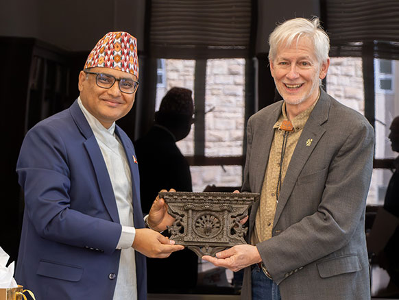 two men holding up an item from Nepal
