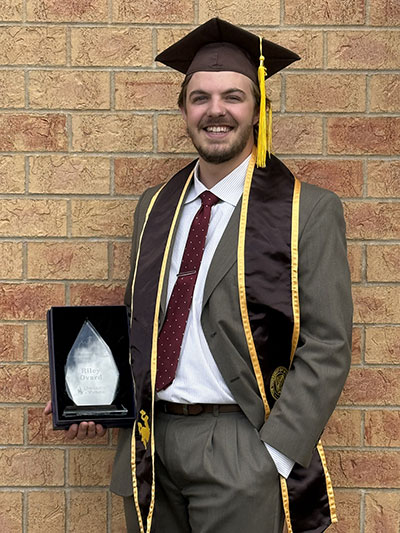 A man stands in graduation robes