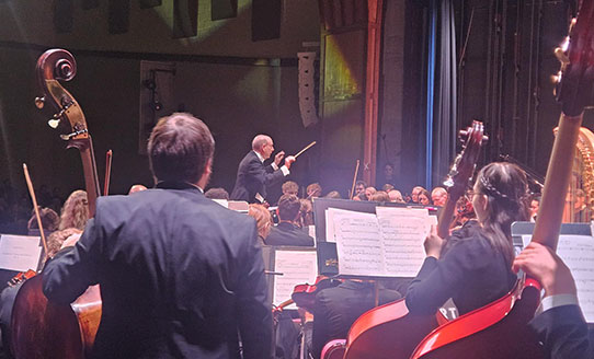 symphony orchestra with a man conducting