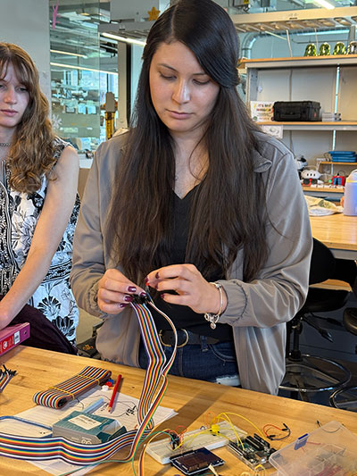 woman working with electrical equipment at a table