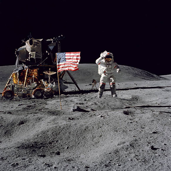 photo of man walking on the moon with the moon lander and American flag in the background