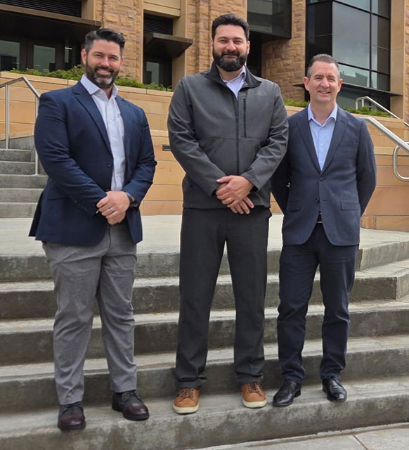three men posing on steps