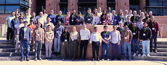 large group of people posing on steps in front of a large building