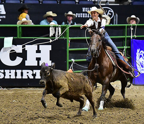 woman on a horse roping a calf