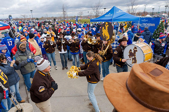 Wyoming marching band members performing for a crowd