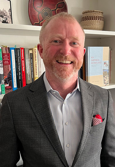 man standing in front of a bookshelf