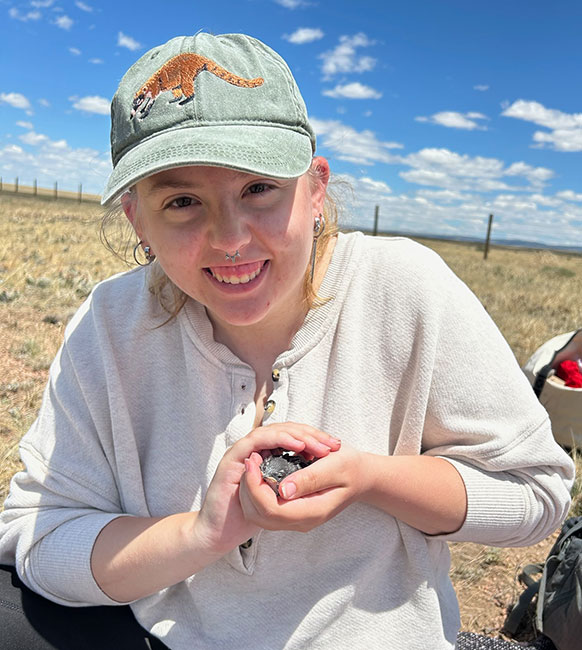 woman cupping a small bird in her hands