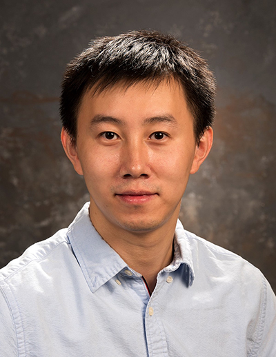 A University of Wyoming professor stands in front of a neutral background.