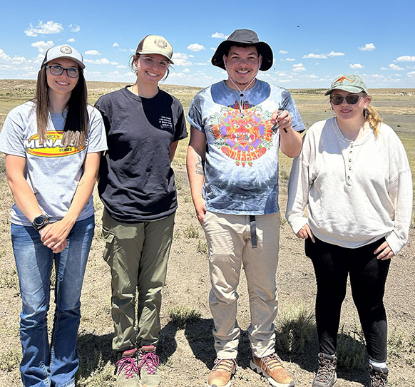 four people posing on the prairie