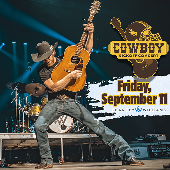 Chancey Williams plays a guitar on stage.
