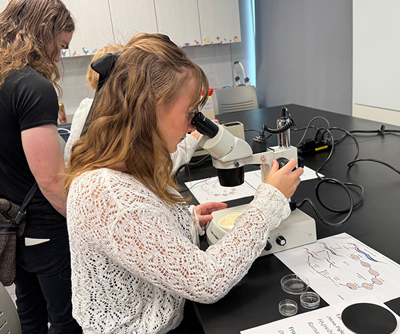 woman looking through at microscope