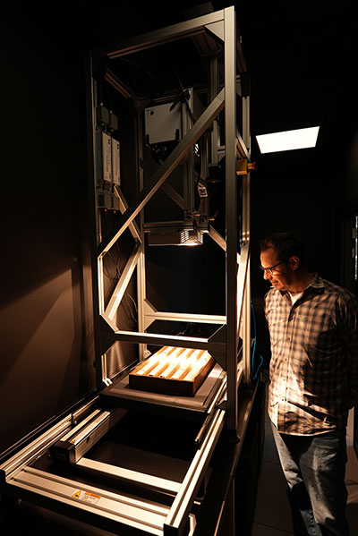 man standing beside a large piece of lab equipmen