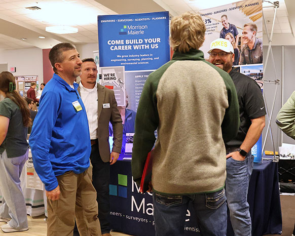 people talking around some posters at an event