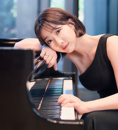 woman leaning her head on a piano