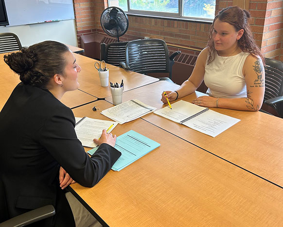 two people sitting across a table from each other