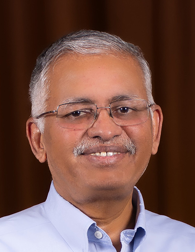 A man wearing glasses smiles.