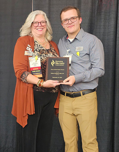 woman and man holding an award plaque
