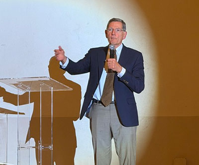man with a microphone beside a podium