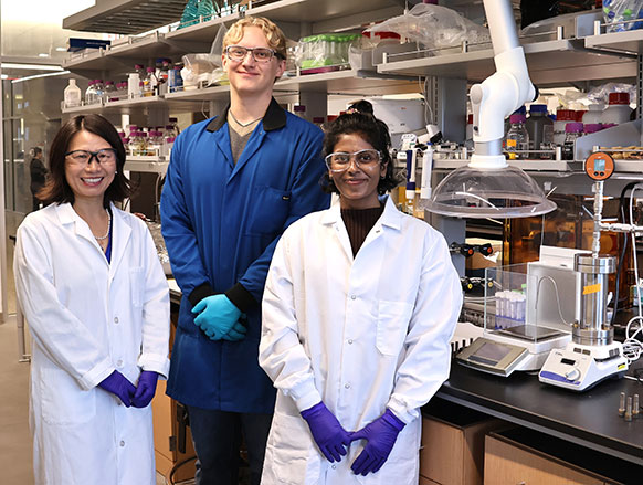 three people posing in a lab