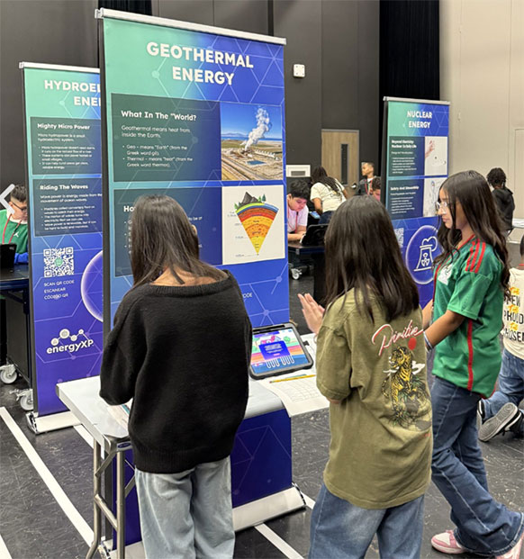 people standing in front of posters and learning stations