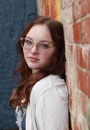 woman leaning against a brick wall