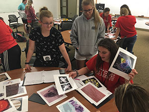 group of students around a table looking at photos