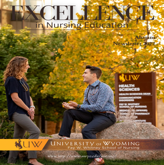 Two students sit on rocks and have a conversation on campus