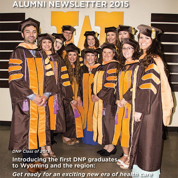 Graduate students stand in their graduation regalia