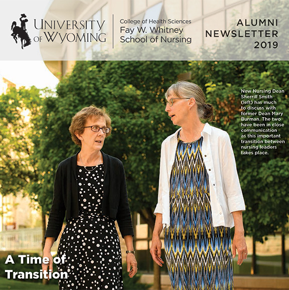 Two people walk on campus and have a conversation