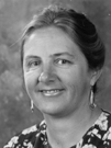 woman with hair pulled back, drop earrings, flowery blouse