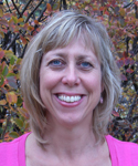 woman with blond/silvery highlights in her hair in front of fall foliage