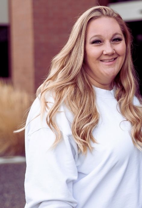 kristine isaak in a white shirt standing outside