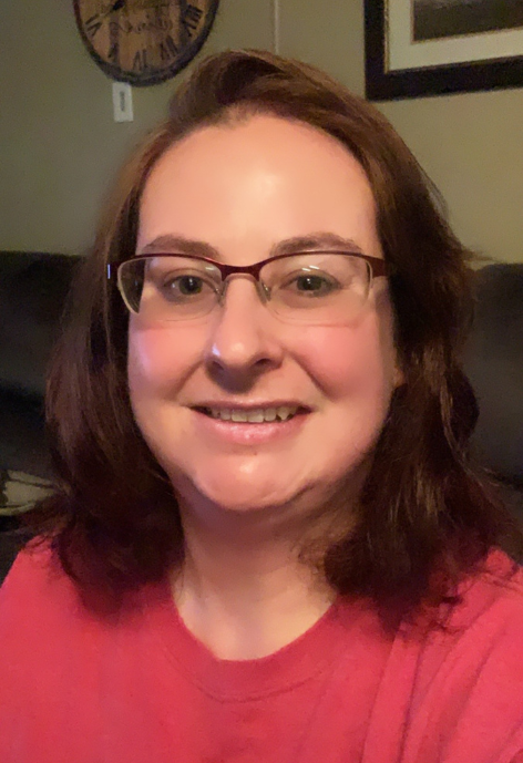 dana kisiel wearing a red shirt sitting on a sofa