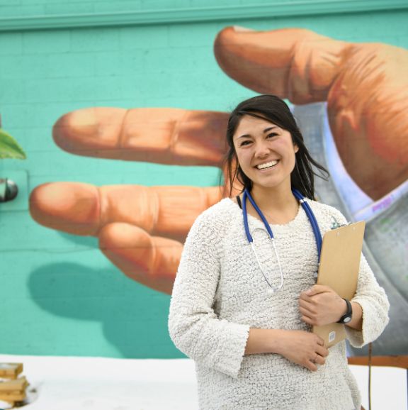 renew morgan lu standing in front of mural