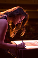 female student signing the Nightingale Pledge