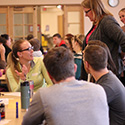 student in lime green shirt asks faculty questions in interprofessional group