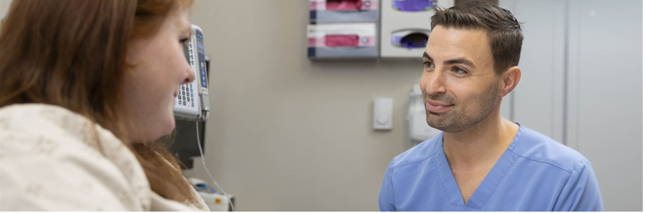 A medical provider speaks with a patient in a doctor's office.