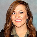 smiling young woman with dark brown reddish wavy long har