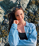 smiling girl with reddish brown hair smiling in front of mountain landscape