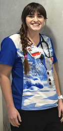 young woman with long dark braid and snowman scrubs in pediatric ward