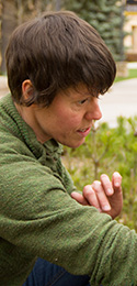 woman with green sweater and dark short hair outside